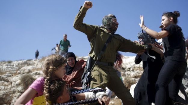 Palestinians scuffle with an Israeli soldier as they try to prevent him from detaining a boy during a protest against Jewish settlements in the West Bank village of Nabi Saleh, near Ramallah. Reuters